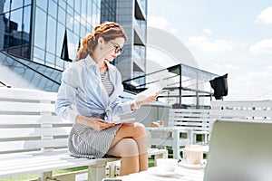 Good-looking fashionable remote worker working on summer terrace