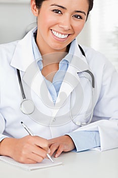 Good looking female doctor writing on a scratchpad