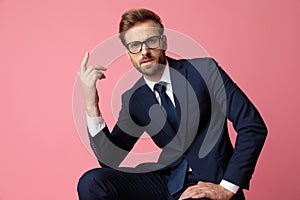 Businessman sitting with resting hands and looking at camera intrigued photo