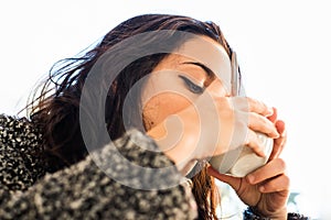 Good looking girl drinking cappuccino - view from below