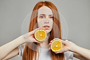 Good looking girl showing oranges to the camera