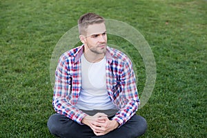 Good looking guy sit on green grass. Man unshaven face peaceful mood. Thinking about future. Existential crisis. Student