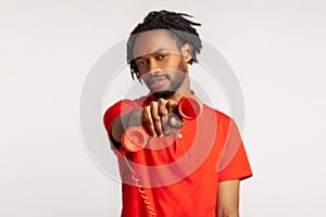 Good looking man with dreadlocks wearing red casual style T-shirt, holding and showing retro phone handset to camera, asking to