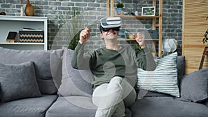 Good-looking man having fun with virtual reality glasses moving hands and head