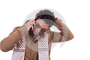 good looking man with sunglasses wearing jacket and scarf talking on mobile phone