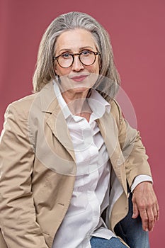 Good-looking mid aged woman in a beige jacket looking at the camera
