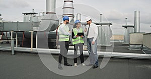 Good looking multiethnic group of workers in a modern building construction site analyzing the plan of construction they