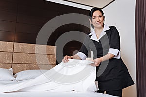 Good looking nice hotel maid changing bedding