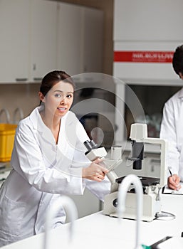 A good looking science student using a microscope