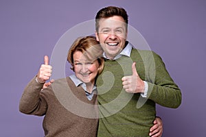 Good looking smiling man and woman mother and son showing OK sign with two hands