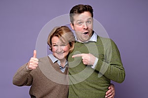 Good looking smiling man and woman mother and son showing OK sign with two hands