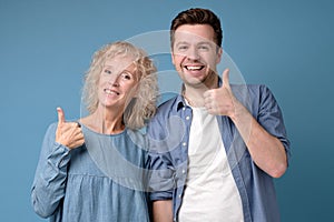 Good looking smiling man and woman showing OK sign with two hands