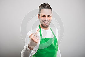 Good looking supermarket employer showing obscene gesture photo