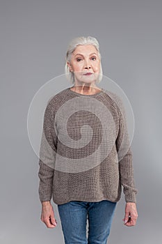 Good-looking tidy senior woman wearing grey knitted sweater
