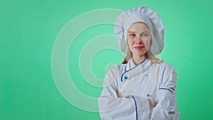 A good looking woman baker in a uniform in a big green background chroma key concept typing something with a finger on