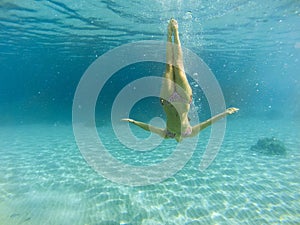 Good looking woman diving under the sea