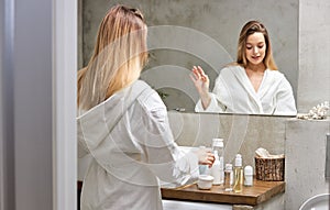 Good-looking woman using cosmetics in bathroom