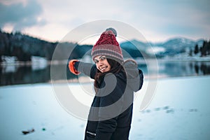 Good looking young lady arrived in amazing landscape with amazing lake and big snowy mountain and forest and turning to