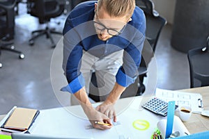 Good looking young man drawing something while working in the office