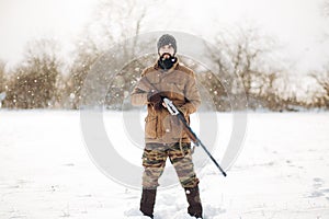 Good looking young man holding a rifle and looking at the camera