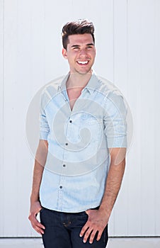 Good looking young man smiling outdoors against white background