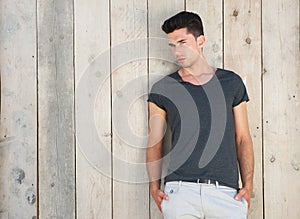 Good looking young man standing outdoors against wall