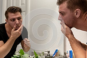 Good Looking Young Man Washing Hands and Face in Home Bathroom Mirror and Sink Getting Clean and Groomed During Morning Routine