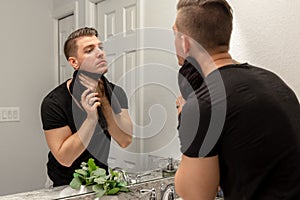 Good Looking Young Man Washing Hands and Face in Home Bathroom Mirror and Sink Getting Clean and Groomed During Morning Routine