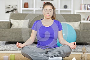 good looking young woman doing yoga in living room