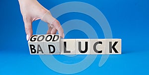 Good Luck and bad Luck symbol. Hand turns a cube and changes the words Bad Luck to Good Luck. Beautiful blue background.