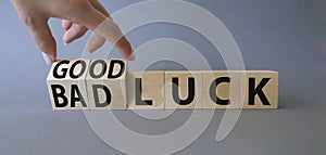 Good Luck and bad Luck symbol. Hand turns a cube and changes the words Bad Luck to Good Luck. Beautiful grey background.