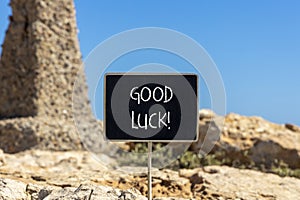 Good luck symbol. Concept words Good luck on beautiful black chalk blackboard. Beautiful brown stone blue sky background. Business