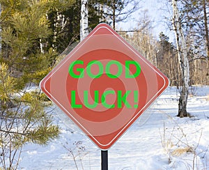 Good luck symbol. Concept words Good luck on beautiful red road sign. Beautiful forest snow blue sky background. Business,