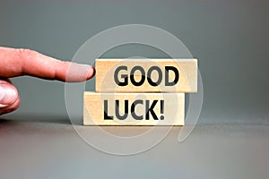 Good luck symbol. Concept words Good luck on beautiful wooden block. Beautiful grey table grey background. Businessman hand.