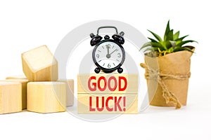 Good luck symbol. Concept words Good luck on beautiful wooden block. Beautiful white table white background. Black alarm clock.