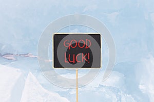 Good luck symbol. Concept words Good luck on beautiful yellow black blackboard. Beautiful blue ice background. Business,