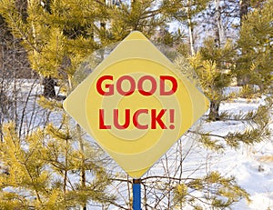 Good luck symbol. Concept words Good luck on beautiful yellow road sign. Beautiful forest snow blue sky background. Business,
