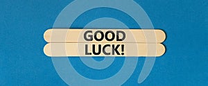 Good luck symbol. Concept words Good luck on wooden stick. Beautiful blue table blue background. Business, motivational good luck