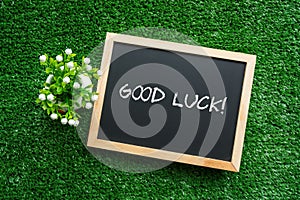 GOOD LUCK! text in white chalk handwriting on a blackboard