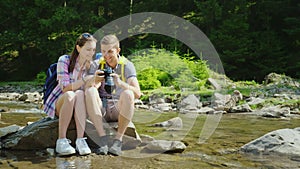 Good memories of the vacation. A couple of tourists are browsing photos on a digital camera