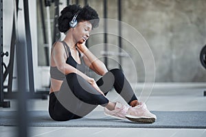 Good mood. African american woman with curly hair and in sportive clothes have fitness day in the gym