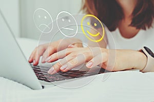 Good mood concept made of emoticon and rating. The girl puts grades on the Internet using a laptop