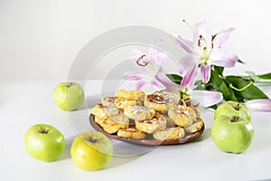 Good morning, breakfast with cheese cakes and green apples on a table in the sun, horizontal