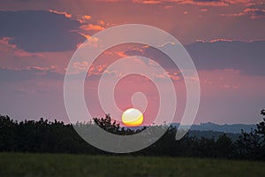 Good morning! Colorful sunrise with big sun ball over the country with lot of sun rays and clouds