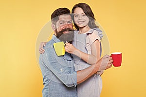 Good morning. Having coffee together. Healthy lifestyle. Family drinking tea. Bearded man and happy girl holding mugs