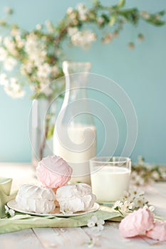 Good morning! Russian marshmallow or zephyr with bottle and glass of milk on tree background. Spring composition.