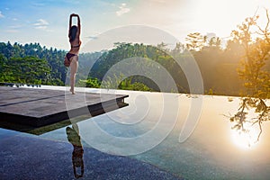 Good morning with woman yoga meditating on sunrise background.