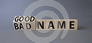 Good name and bad name symbol. Turned wooden cubes with words Bad name and Good name. Beautiful grey background. Business concept