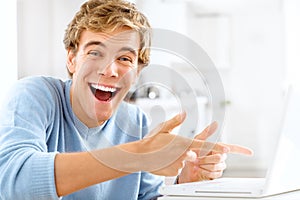 Good news abounds today. Shot of a young man looking shocked while using his laptop.