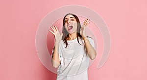 Good news. Portrait of young beautiful girl emotionally posing against pink studio background. Happiness, surprise